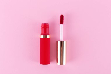 Applicator with liquid red lipstick tube on pink background. Space for text. Mockup