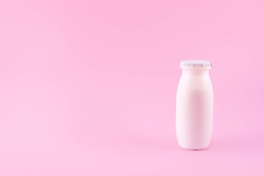 Natural liquid yogurt with probiotics in small plastic bottles on pink background. Healthy, balanced diet food, healthy breakfast, dairy products. Selective soft focus, blurred background.