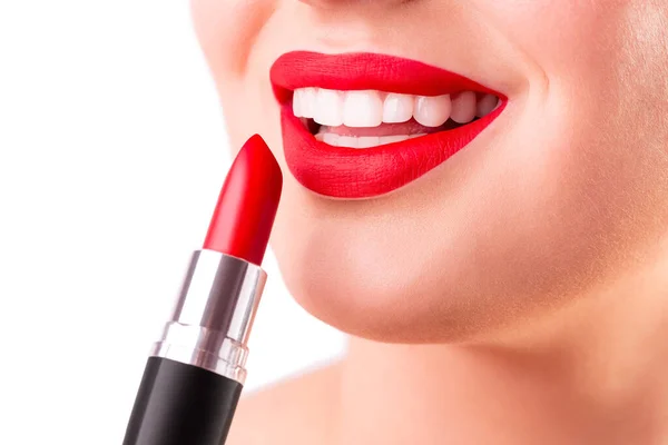 Healthy white smile close up. Beauty woman with perfect smile, lips and white teeth. Beautiful Model Girl with red lips applying red lipstick. Teeth whitening and cleaning, dental care.
