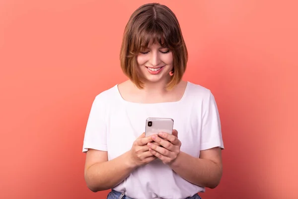 Close-up portrait of her she nice-looking attractive lovely pretty focused cheerful cheerful brown-haired woman using digital device chatting isolated over light pink pastel color background