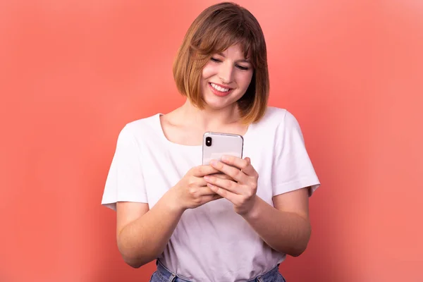 Close-up portrait of her she nice-looking attractive lovely pretty focused cheerful cheerful brown-haired woman using digital device chatting isolated over light pink pastel color background