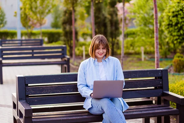 Photo of attractive lady student sit on bench in green park browsing notebook chatting friends do home tasks inspiration nature beauty harmony wear white t-shirt park outdoors