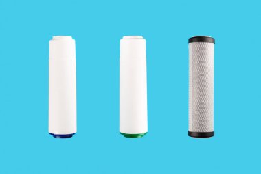 set three of cartridges for water filter isolated on blue background.  Concept of water treatment technology. filter cartridges to domestic water treatment systems 