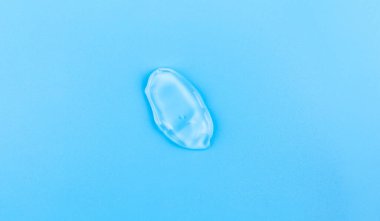Moisturizing transparent face cream gel smeared isolated on blue background.
