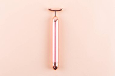 Face massager vibration roller on beige background. Facial massage and beauty concept, relax and spa. Place for text.