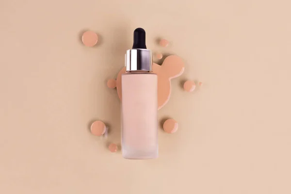 Spilled liquid foundation. Mockup glass bottle of correction cosmetic product with pipette and brush for make up on red background. beauty branding concept. Background
