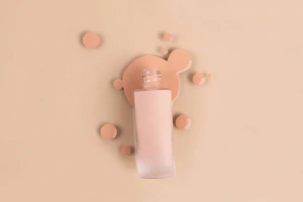 Spilled liquid foundation. Mockup glass bottle of correction cosmetic product with pipette and brush for make up on red background. beauty branding concept. Background