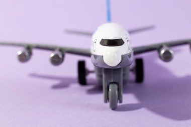 Oyuncak uçağın yakın planında mor bir nesne var. Model uçak kapatın. Tatil ve iş seyahati kavramı. asgari konsept