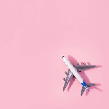 Beyaz model uçağın üst görüntüsü, izole edilmiş pembe arka planda uçak oyuncağı. Fotokopi alanı olan düz bir yer. Trip veya seyahat afişi