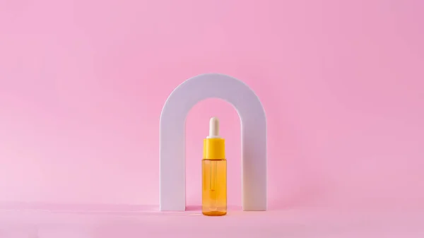 Cosmetic yellow bottle with vitamin c serum in arch. Skin care cosmetic. Hyaluronic acid oil, serum with collagen and peptides