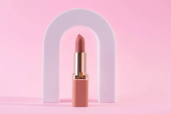 Abstract background with geometric forms  for product presentation nude lipstick, lipgloss on pink background. arch to show cosmetic products. beuty concep