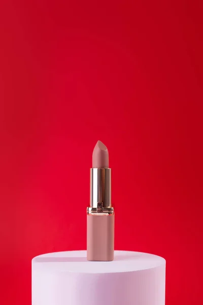 Lápiz Labial Beige Desnudo Podio Blanco Sobre Fondo Rojo Plantilla —  Fotos de Stock