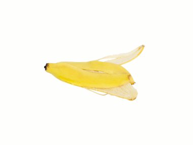 Bir muz kabuğu, sonuna kadar yenen altın sarısı, geriye sadece kabuğu katı atığa dönüşmüş. Stüdyoda çekilen beyaz arka planda kesme yolları ve izole edilmiş kopyalama alanı.