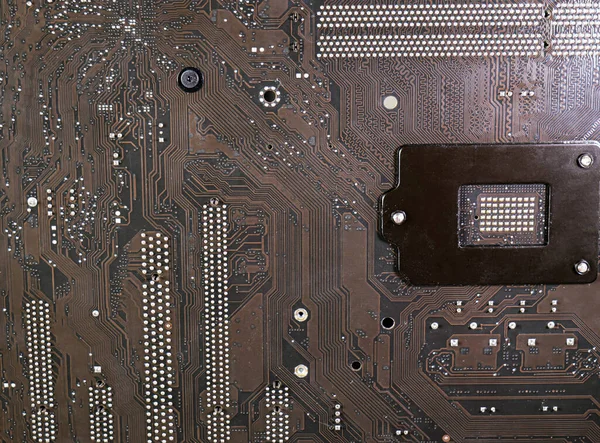 The surface of the motherboard, dark brown, has a pattern of data paths, and the current has a point caused by lead solder. It\'s the circuit board under the CPU.