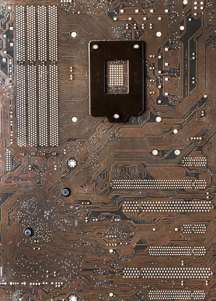 The surface of the motherboard, dark brown, has a pattern of data paths, and the current has a point caused by lead solder. It\'s the circuit board under the CPU.