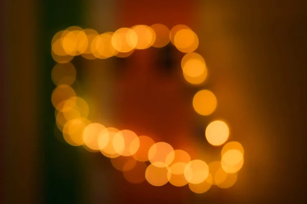 Take the light out of focus to create an oval, amber-colored bokeh in the darkness.