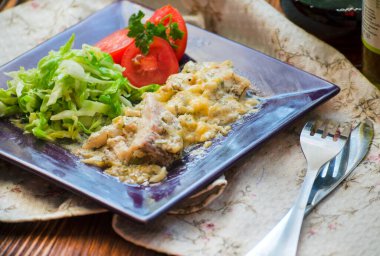 Beyaz tavuk eti, ekşi krema sosu ve tabakta sebze.