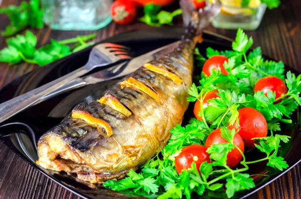 用柠檬烤的鲭鱼 有蔬菜特写的盘子里的鱼 图库图片