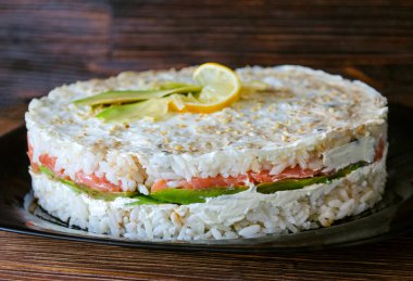 Somon ve avokado tabağında büyük suşi keki.