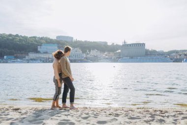 Kumsalda yürüyen mutlu genç çift. Yakışıklı bir adam kollarında bir kız taşıyor. Sevgi dolu bir çift eğleniyor. Gülüyorlar, sarılıyorlar. Toplam çerçeve. Metin için yer