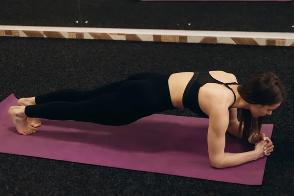 健康的年轻女运动员穿着运动服热身伸展身体肌肉坐在体育馆的垫子上 健康的女瑜伽教练做运动锻炼健身训练 复制空间 — 图库照片
