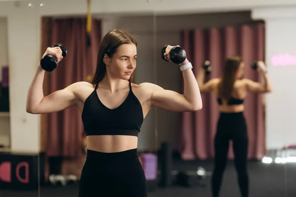 Stark Tjej Svarta Sportkläder Lyfter Hantlar För Att Träna Armmusklerna — Stockfoto