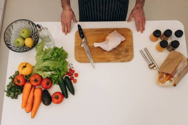 Masada yemek pişirmek için yemek. Adam mutfakta yemek pişiriyor. Sebzeler. Korkak. Tavuk pişiriyorum.