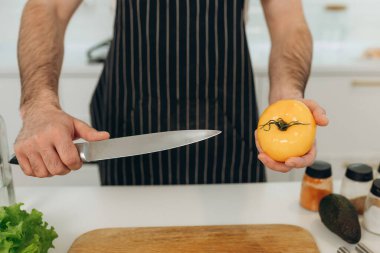 Sarı domatesli mutfak bıçağının yakın plan portresi. Yemek pişirme