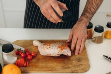 Adam tavuk pişiriyor. Yemek pişirme portresi.