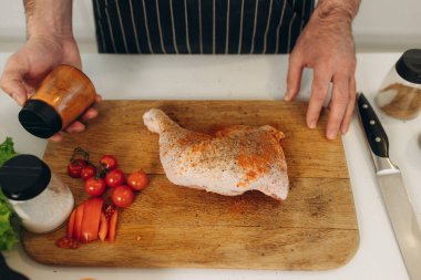 Adam tavuk pişiriyor. Yemek pişirme portresi.