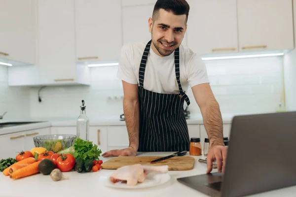 Young Man Watching Video Recipe Laptop While Cooking Vegetables Kitchen — Stock Photo, Image