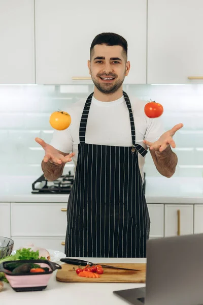 Smiling Guy Prepares Vegetables Kitchen Dressed Black Apron — Stock Photo, Image