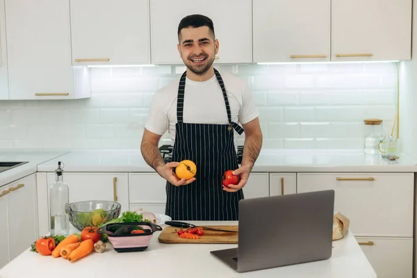 Smiling Guy Prepares Vegetables Kitchen Dressed Black Apron — Stock Photo, Image