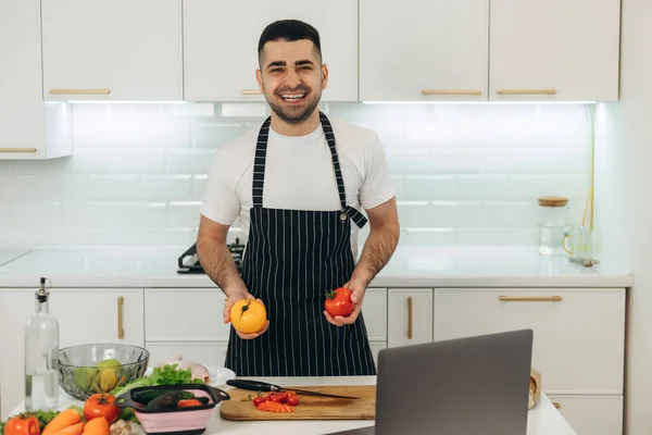 Smiling Guy Prepares Vegetables Kitchen Dressed Black Apron — Stock Photo, Image