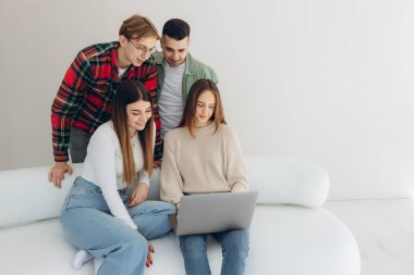 Bir grup arkadaş dizüstü bilgisayardan bir şeye bakıyor.