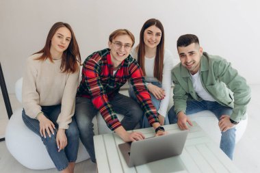 Bir grup arkadaş dizüstü bilgisayardan bir şeye bakıyor.