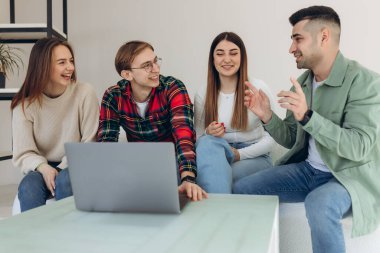 Bir grup arkadaş dizüstü bilgisayardan bir şeye bakıyor.