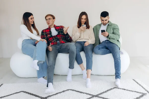 Birkaç arkadaş evde telefon kullanırken arkadaşlarını görmezden geliyor.