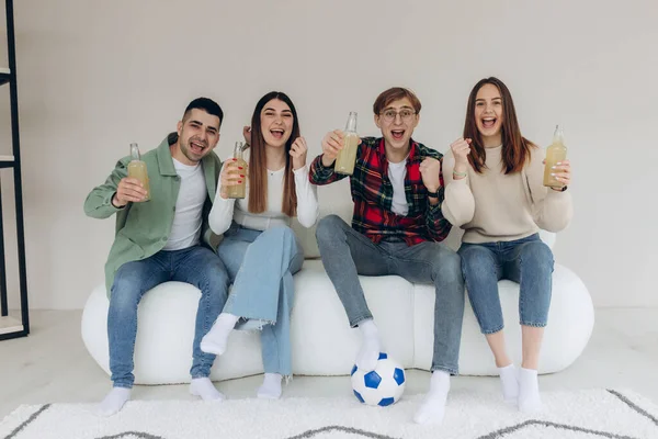 Mutlu arkadaşlar ya da futbol taraftarları televizyonda futbol izleyip duygusal olarak zaferi evde kutluyorlar. Arkadaşlık, spor ve eğlence kavramı