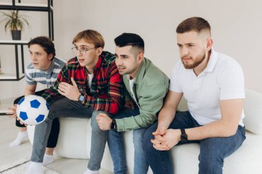 Televizyonda futbol maçı izleyen bir grup arkadaş. Futbol hayranları
