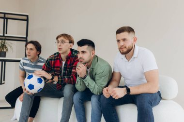 Televizyonda futbol maçı izleyen bir grup arkadaş. Futbol hayranları