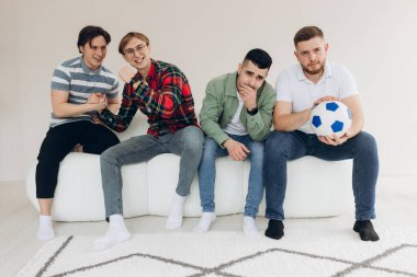 Televizyonda futbol maçı izleyen bir grup arkadaş. Futbol hayranları