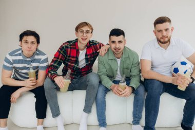 Televizyonda futbol maçı izleyen bir grup arkadaş. Futbol hayranları