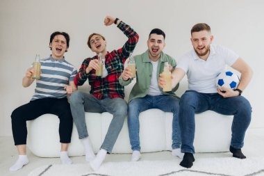 Bir grup arkadaş televizyonda maç izleyip golü kutluyorlar.