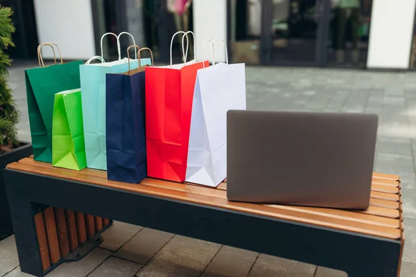 Laptop and shopping bags in the mall. Online shopping concept