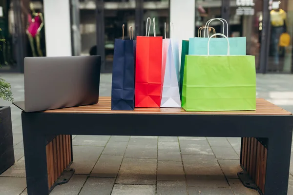 Laptop and shopping bags in the mall. Online shopping concept