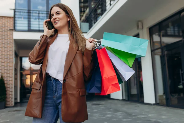 Junge Frau Mit Bunten Tüten Auf Der Straße Und Handy — Stockfoto