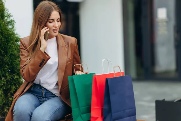 Junge Frau Mit Bunten Tüten Auf Der Straße Und Handy — Stockfoto