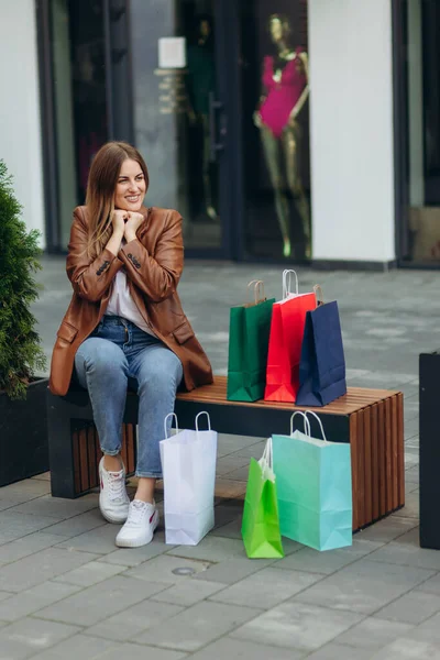 Portrait Smiling Girl Sitting Mall Girl Holding Colored Shopping Bags — Foto Stock