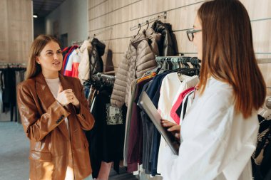 Profesyonel Alışveriş Asistanı Dijital Tablet Kullanarak Kadın Müşterinin Kıyafet Almasına ve Kişisel Stili Geliştirmesine Yardım Ediyor. Boş Alan